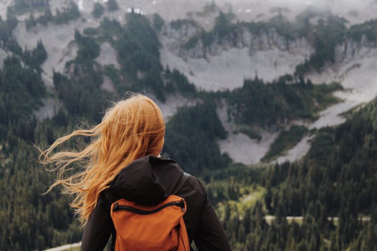 a girl traveling with a backpack through nature 