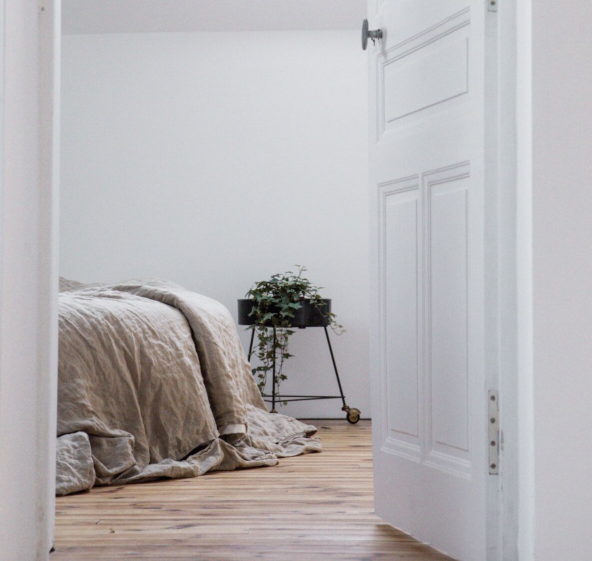 A minimalist bedroom with linen bed sheets